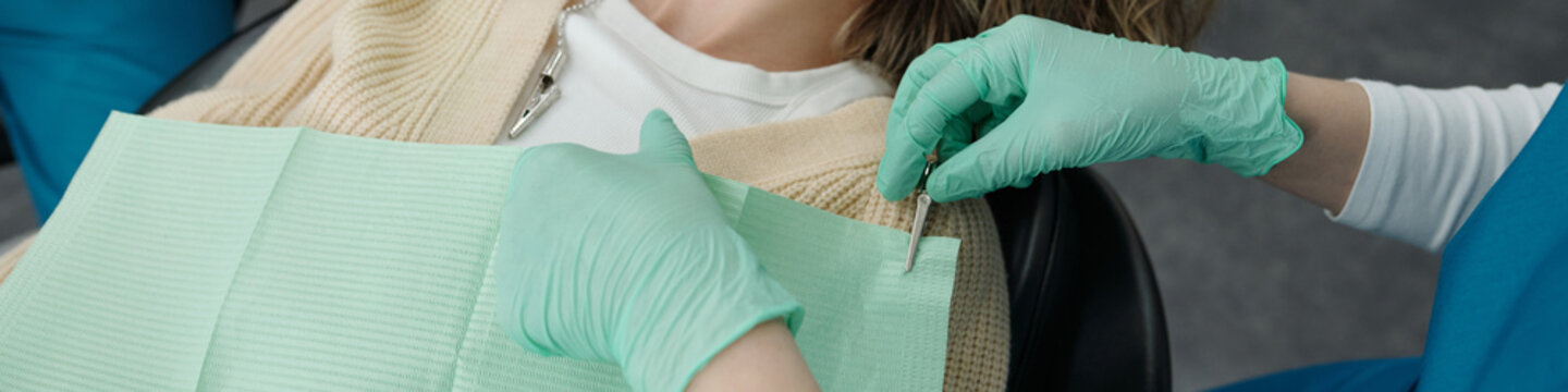 Assistant Preparing Patient for Dental Treatment High Angle