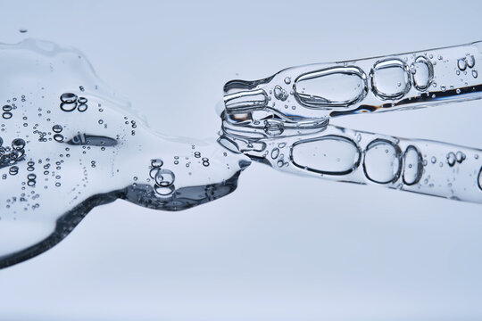 The texture of serum with spicules in a dropper on a blue background.