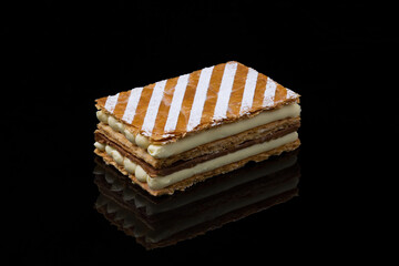 Classic Mille-Feuille Slice with Chocolate and Powdered Sugar Stripes on Black