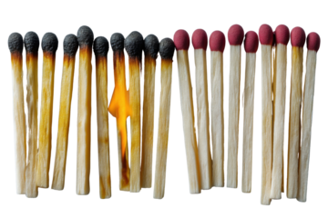 Burnt Matchsticks: A striking composition of burnt and unburnt matchsticks on surface symbolizes transformation, with the central matchstick ablaze, igniting change