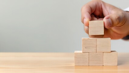 Building blocks hand stacking wood block cube construction business strategy concept