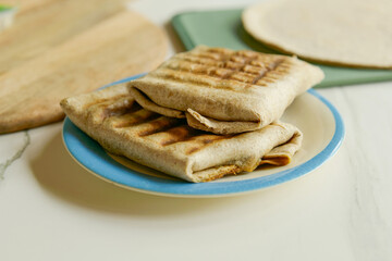 Preparing vegetarian wraps, filling wrap with spinach and potato, gorgonzola cheese, chickpeas and garlic and green herbs