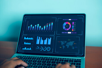 Business analysts use computers and dashboards to analyze data and metrics connected to databases...