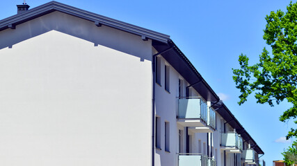 Residential homes with modern facade. Terraced family homes in newly developed housing estate. The real estate market in the suburbs. New single family houses in a new development area. 