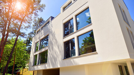 Eco architecture. Green tree and new residential building. Harmony of nature and modernity. Modern apartment building with new apartments in a green residential area.