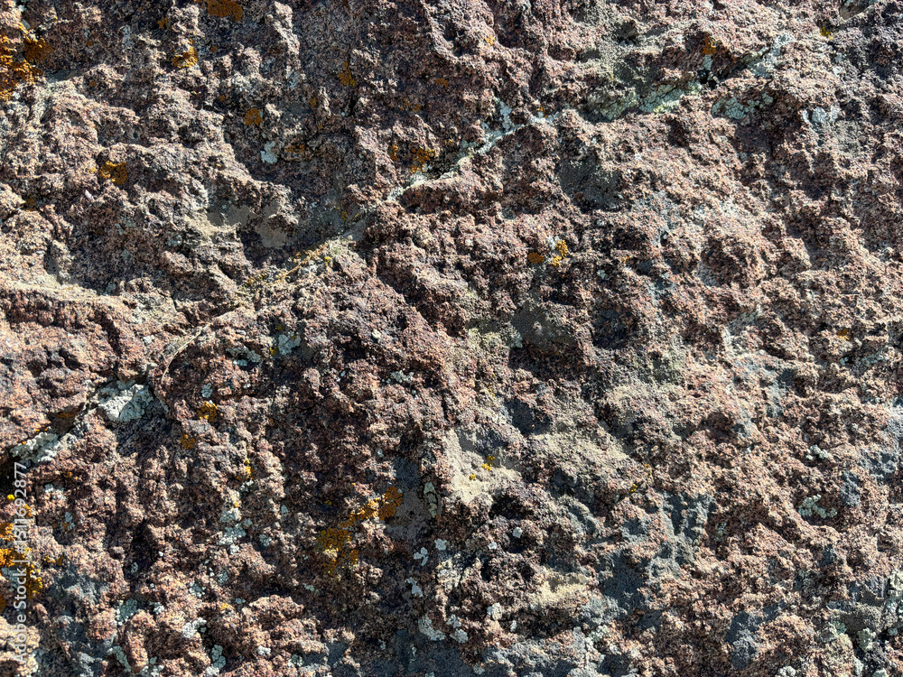 Poster rough volcanic rock texture with pink and gray mineral patterns and yellow lichen for nature backgro