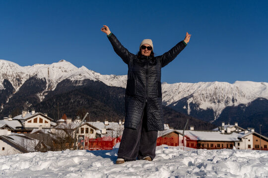 Woman Alps Winter: Joyful celebration snowy mountains village background sunny day.