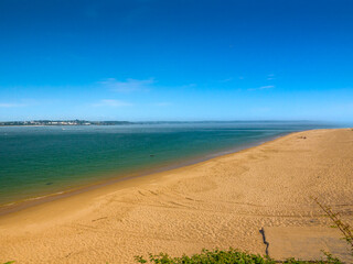 Expansive sandy beach with Tenby town in the distance (Priory Bay, Caldey Island, Tenby, Wales, United Kingdom)