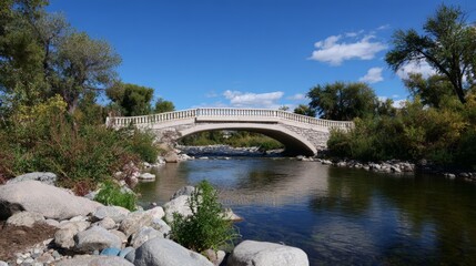 Fototapeta premium Incomplete bridge over river with verdant surroundings on a clear day