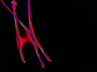 Glowing English letter N. On a black background with colored neon lines, a letter of the English alphabet is written by hand. The letter glows pink-red, creating a green-blue halo around it.