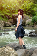 Asian Woman Standing on River Rocks Enjoying Nature in Forest During Outdoor Adventure