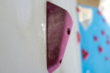 Climbing wall, colorful fixtures attached to the wall.
