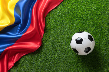 A soccer ball on a green field with a Colombian flag. High quality photo