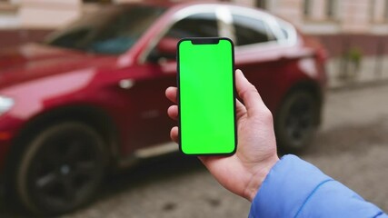 NEW YORK - December, 19 2020: Close up hands young man using phone with vertical green screen phone on background red car on street city blurred internet chrome outdoor. Cellphone media device modern - Powered by Adobe