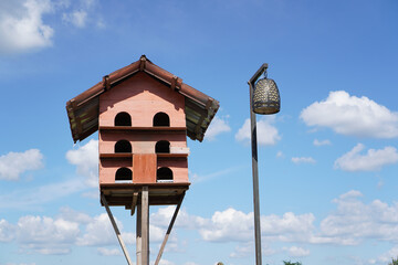 Wooden Multi‑Level Birdhouse Against Blue Sky
