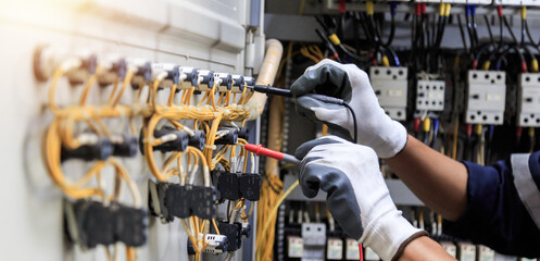 Electrician use meters to measure current at devices in the MDB cabinet, for safety in the electrical system.