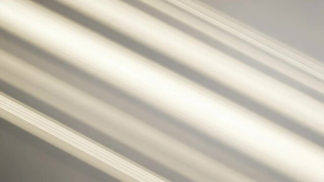A bright light streaks across smooth, gray background, casting soft glow.