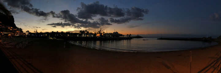 Fototapeta premium Panoramic view of a serene beach at twilight with vivid colors