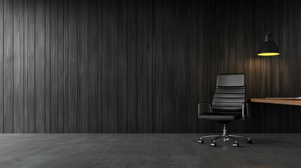 A black office chair sits in front of a wooden wall with a lamp.