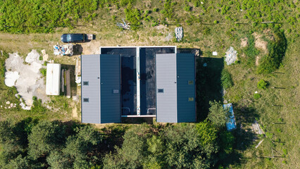 Aerial top down view of a semidetached house and land under final construction work, prace budowlane, budowa nowych doom, widok z drona © Robert
