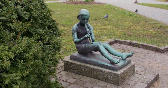 statue of a small child playing an instrument flute Haugesund,