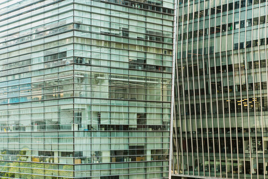 Close-up of a glass building with layered reflections and structural lines, highlighting the interplay of light, materials, and urban design.