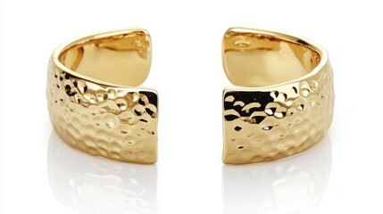 Elegant wide gold cuff bracelet with hammered texture resting on white