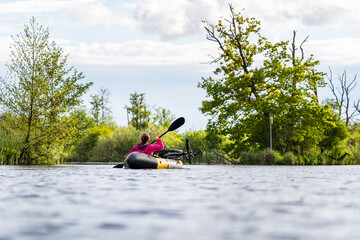 Woman Bikerafting on the Peene River in Summer Surrounded by Wild Nature