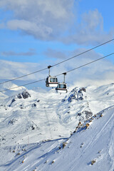 Vintage ski lifts in Courchevel ski resort by winter, French alps.