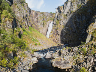 Aerial marvel of Norway: the Voringsfossen waterfall, framed by rugged cliffs and emerald greenery. An elegant drone panorama of wild Scandinavian nature.