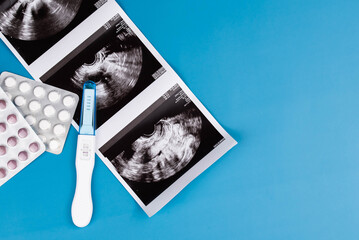 Positive pregnancy test, gynecological ultrasound image, prenatal vitamins, medications, symbolizing pregnancy, family planning, and maternal health. Concept of prenatal care, and expecting a baby.