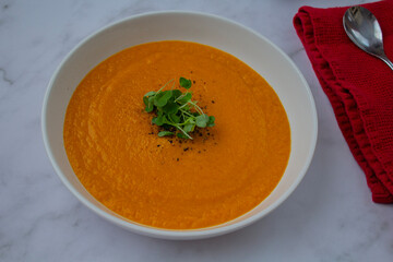 Fresh carrots, onions, and spices laid out for preparing healthy homemade soup