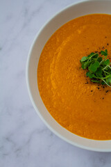Fresh carrots, onions, and spices laid out for preparing healthy homemade soup