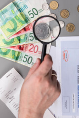 Israel currency New Israeli shekel (NIS) banknotes and agorot coins, with bills for electricity, water, and taxes, concept of inflation, economic crisis, rising prices, and financial management.