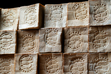 Rows of  of bars of aged and dry traditional aleppo organic laurel soap as a  background
