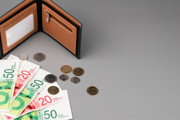 Israel currency New Israeli shekel (NIS) banknotes and agorot coins and empty wallet, concept of saving money, inflation, economic crisis, rising prices, and personal finances.
