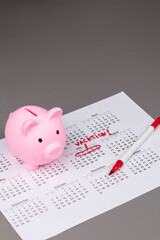 Piggy bank on calendar with the words 'Vacation' written on it, symbolizing saving money for travel, financial planning, and budgeting for a dream getaway. Concept of vacation savings and planning.