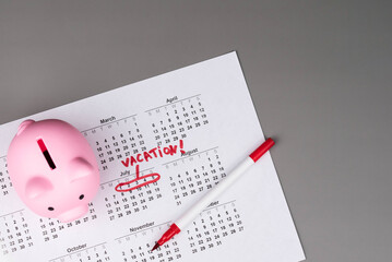 Piggy bank on calendar with the words 'Vacation' written on it, symbolizing saving money for travel, financial planning, and budgeting for a dream getaway. Concept of vacation savings and planning.