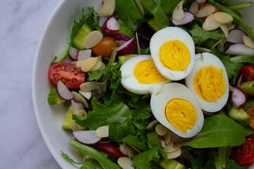 Fresh and vibrant homemade salad topped with sliced eggs and a light vinaigrette