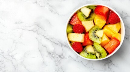 A bowl of mixed fruit on a marble countertop.
