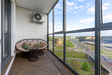Glazed Balcony with Rattan Lounge and Cityscape