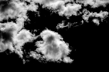 A powerful image of clouds illuminated by intense light against a black sky, revealing the raw energy and complexity of weather systems and cloud formations.