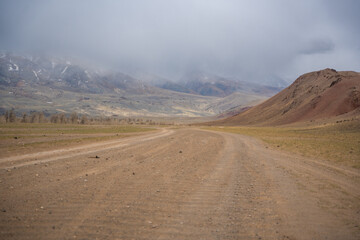 Gravel road through deserted valley leading from Mars Altai Russia. Remote pathway to famous colorful geological landmark.