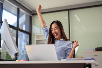 Overjoyed charming excited woman business woman worker using smartphone and laptop working in...