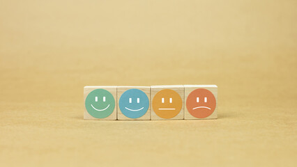 Four wooden blocks with a circular sticker and a different emoticon, visually representing a...