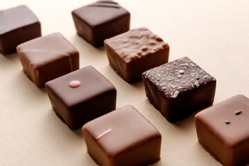 Minimal overhead shot of chocolate squares on beige background, elegant candy dessert composition