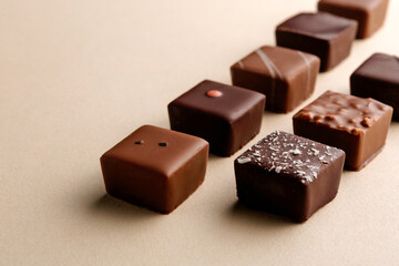 Minimal overhead shot of chocolate squares on beige background, elegant candy dessert composition