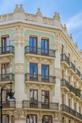 Elegant Valencia Apartment Building Facade With Ornate Details And Balconies. Traditional Spanish architecture, urban residential, decorative elements, clear sky, historic charm.