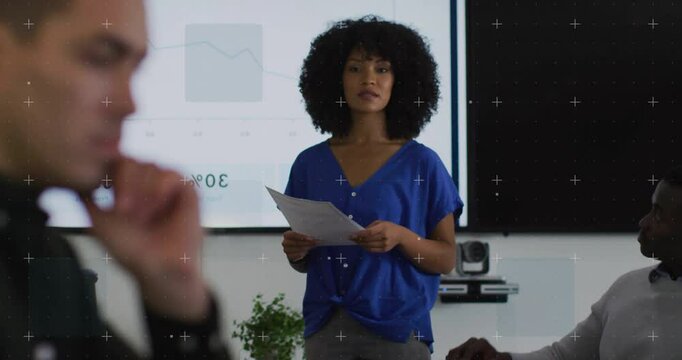 Meeting starting presenter glancing notes and pointing at business chart showing downward trend