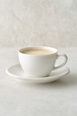 Obraz premium beautifully crafted coffee drink in pristine white cup on light background emphasizing one element